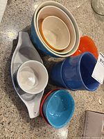 Assorted colourful bowls, oval baker and ramekin grouped on countertop