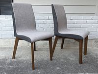 Front three-quarter view of both chairs showing upholstery contrast and leg style