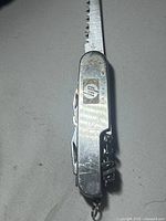 Pocket knife closed with saw blade extended, showing HP logo