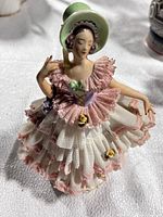 Full view of porcelain lady figurine showing dress layers and pose