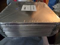 Side view showing stacked sealed foil pans