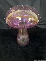 Full view of purple iridescent glass mushroom sculpture on black background
