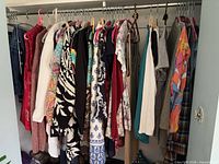 Full closet view of assorted women’s garments on hangers