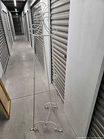 Full view of white metal easel standing in storage unit hallway