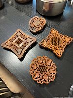 Top view of all four carved wooden trivets on table