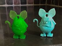 Front view of both Rat Fink charms, green and blue, showing detail and condition