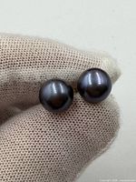 Close-up of both pearls showing color and luster