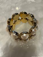 Angled view showing domed faux pearls and gold-tone bezels