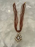 Full view showing entire multi-strand necklace and pendant