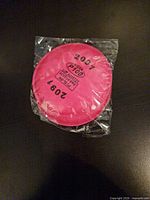 Front view of sealed 3M 2091 P100 pink filter showing model and NIOSH markings