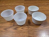 Top view showing three plain milk glass and two ribbed ceramic ramekins