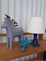 Lamp, wooden horse and jack decor on shelf