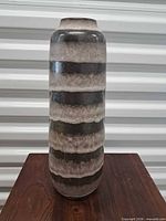 Full view of striped cylindrical vase on table