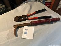 Bolt cutters and slide hammer nail puller laid side by side