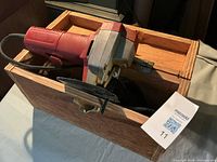 Red Milwaukee jigsaw inside wooden box