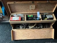 Open wooden toolbox showing compartments and contents