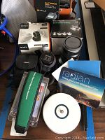 Overview of lot: Rokinon lens, Lensbaby lens, Shutterboss box, adapter box, strap, pouch, Alpine Labs device