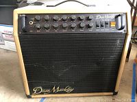 Front view of Dean Markley amplifier showing control panel, speaker grille and wooden casing with the Dean Markley logo