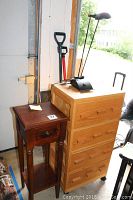 Dark wood Pier 1 side table with drawer, light wood cabinet with 12 small drawers, and black table lamp with curved neck