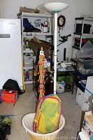 Garage setting showing the 71 inch floor lamp with kids stickers, wooden Beanie Baby rack behind it with clip holders.