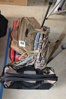 Stacked view of multiple bags from top, showing different colors and styles including brown, camouflage, and black bags.