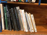 Books on shelf showing titles Embracing Earth, Joseph Sudek, The Beatles Anthology, Miles Davis The Columbia Years, Rolling Stone Images of Rock and Roll, Celtic Living, Stay This Moment and others.