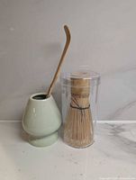 Full set showing ceramic stand with scoop inserted, whisk inside clear tube