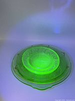 Plates glowing under UV light to show uranium content