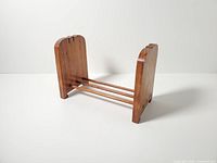 Front angled view showing scalloped end panels and three dowels