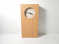 Front view showing rectangular case, recessed dial, veneer color