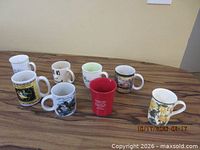 Eight assorted printed ceramic mugs on wood surface