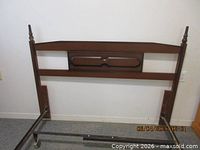 Front view wood headboard attached to metal rail ends