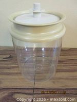 Large canister showing clear body and cream collar with white lid insert