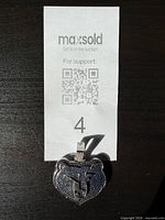 Pendant with MaxSold ticket for scale