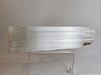 Full side view of entire selenite log on clear stand