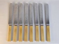 Full set of eight knives aligned to show blades and handles