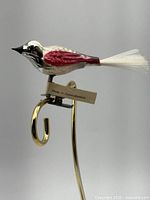 Full side view of bird ornament on display hook showing paint, tail and tag