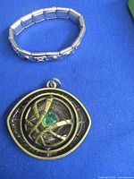 Front view of pendant and bracelet on blue background