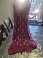 Full front view of burgundy chemise slip displayed on table
