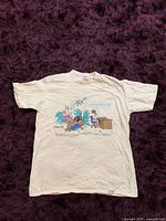 Full view of front of T-shirt laid flat displaying graphic and color