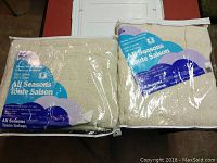 Two new woven thermal blankets individually packaged, cream colored, made from 100% cotton.