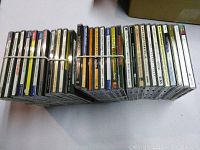 Top view showing 30 music CDs in jewel cases bundled together with rubber bands.