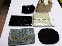 Overview of six evening bags arranged on a white surface showing variety of styles and textures.