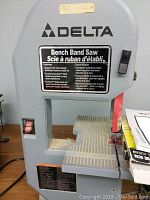 Front view of Delta bench band saw showing cast iron table and blade