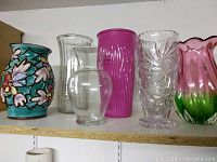 Shelved view of all six vases showing sizes, colors, and detailing.