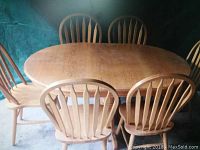 Photo of the oak table with six chairs around it showing the rounded top.