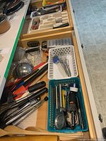 Drawer with assorted utensils, graters, whisks, thermometers, peelers