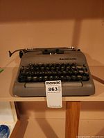 Front view of gray Smith-Corona Sterling typewriter showing full keyboard and body