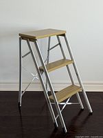 Full view of folded-out ladder showing three steps and frame