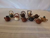 Group view of all ten miniature teapots lined up